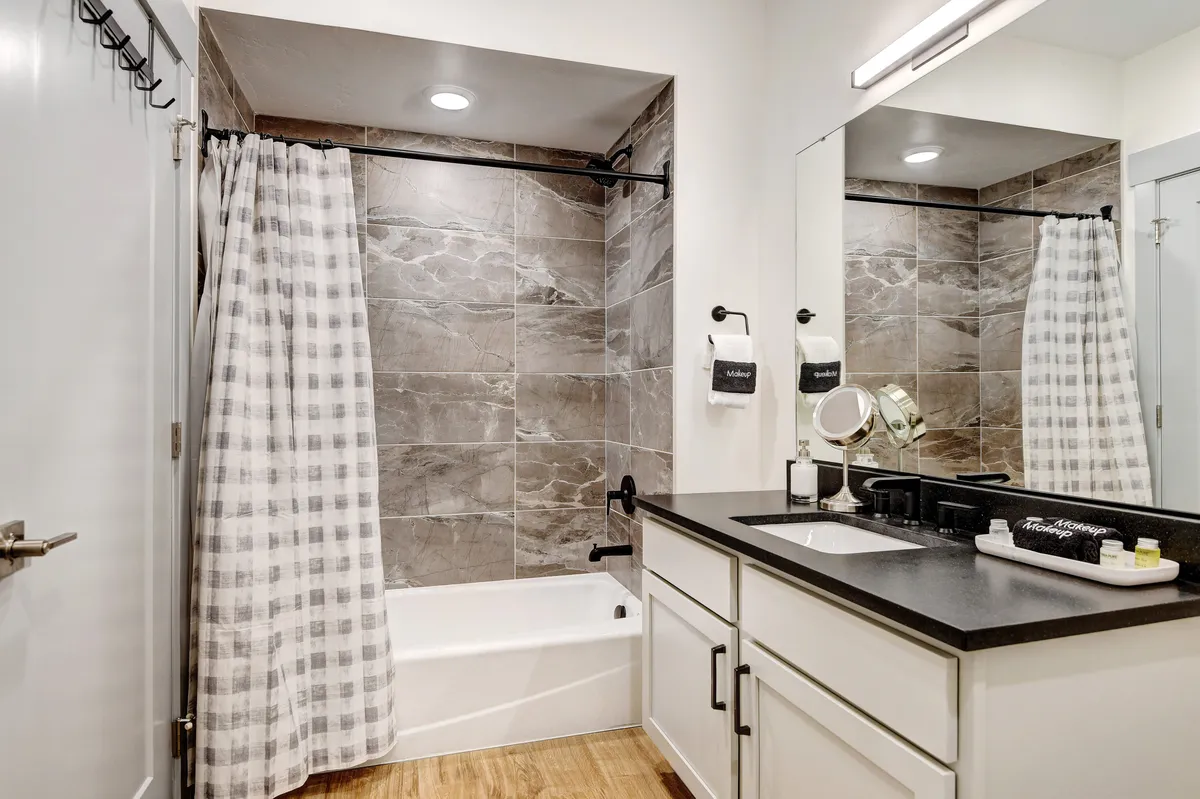 A stylish bathroom with a soaking tub, modern sink, and elegant tiles, bathed in natural light. The space feels luxurious and refreshing, ideal for unwinding after a day of adventure.